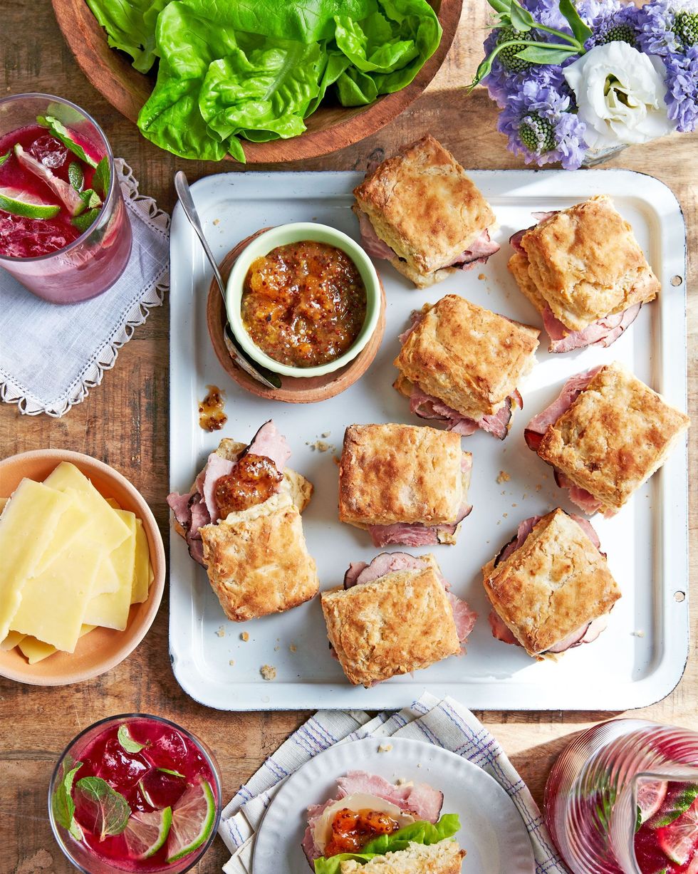 ham biscuit sandwiches on a white serving tray with a bowl of apricot mustard