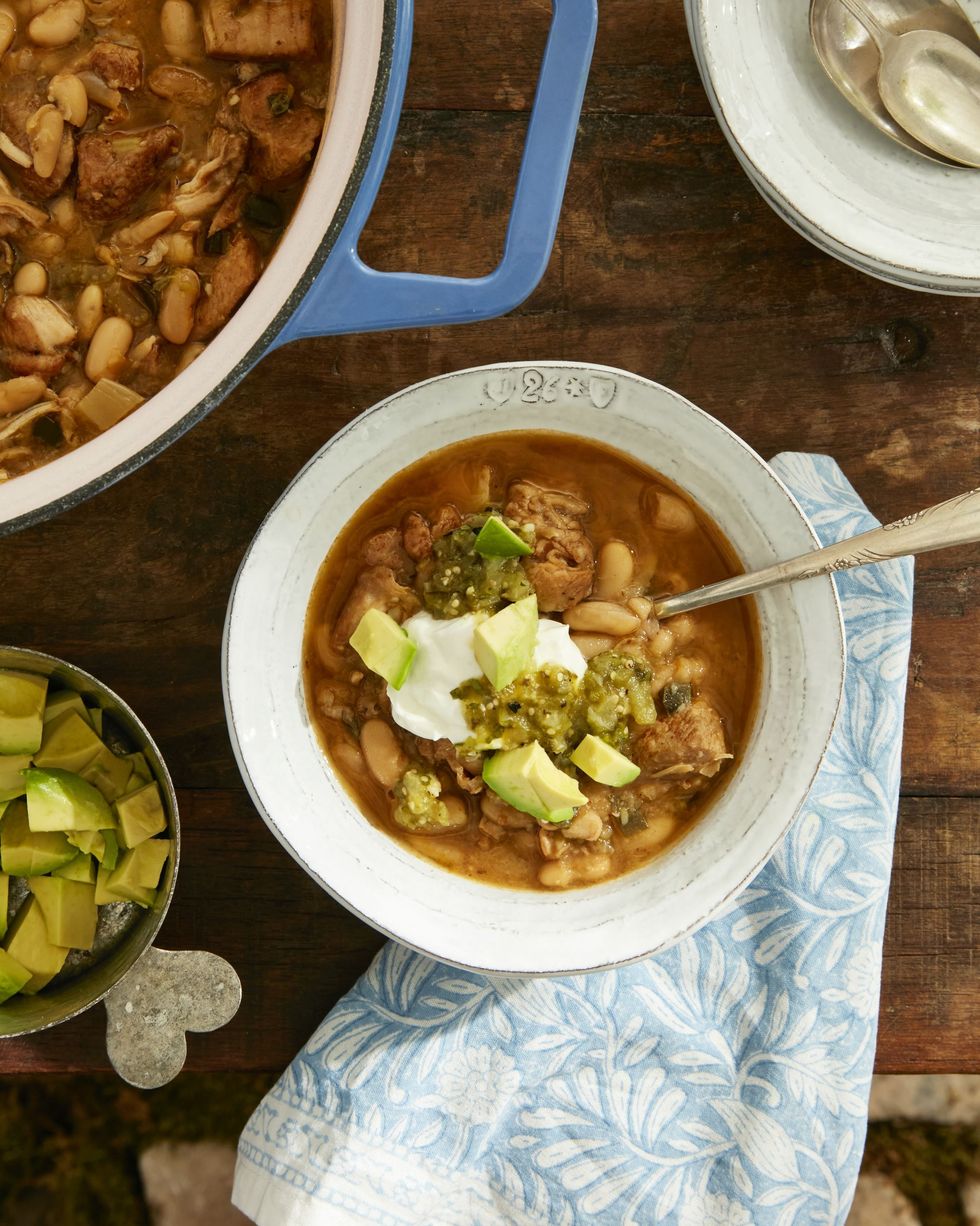 white turkey and poblano chili in a bowl and topped with a dollop of sour cream and diced avocado